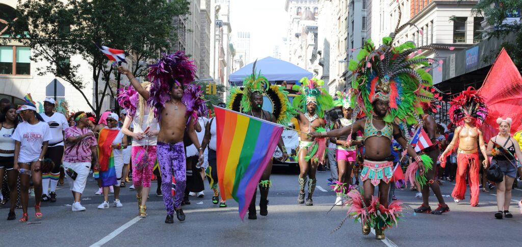 Foto di manifestazione Gay Pride con bandiera arcobaleno al centro